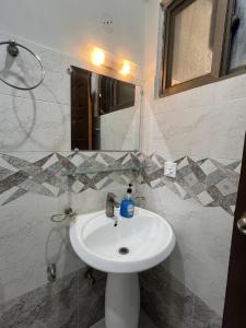 a bathroom with a white sink and a mirror at Family-Friendly Luxury Apartment Home Away From Home in Islamabad