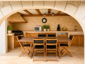 an archway in a kitchen with a wooden table and chairs at villa plaisirs in Saint Paul de Vence
