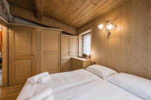 a bedroom with a bed with two towels on it at Cesa Linda by AMA Val di Fassa in Campitello di Fassa +5 photos