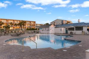 a swimming pool in a courtyard with tables and chairs at The Gardens 703 in Tybee Island