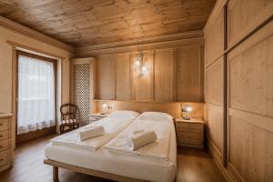 a bedroom with a bed and a wooden ceiling at Cesa Linda by AMA Val di Fassa in Campitello di Fassa