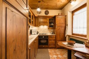 a kitchen with wooden cabinets and a table in it at Cesa Linda by AMA Val di Fassa in Campitello di Fassa