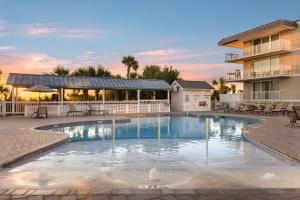a swimming pool with chairs and a building at The Gardens 703 in Tybee Island