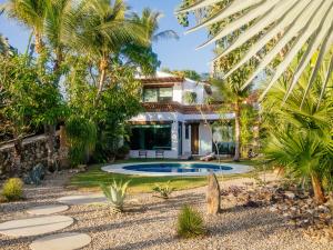 a house with a swimming pool and palm trees at Casa de la Luna in Puerto Escondido