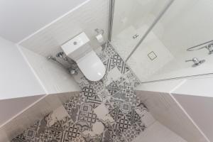 a bathroom with a toilet and a tile floor at Vila Komoda in Palanga