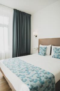 a bedroom with a large bed with blue and white sheets at Shelter-rooms in Buysinghen
