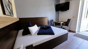 a hotel room with a bed and a tv at Pension Schwarze Pumpe in Spremberg