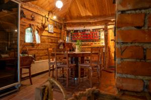 a dining room with a wooden table and chairs at Etno Kuca Bajka in Mataruška Banja