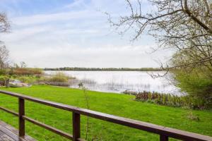 a view of a lake from a wooden fence at Luxury Lakeside Retreat in Ringsted