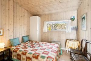 a bedroom with a bed and a table and a window at Luxury Lakeside Retreat in Ringsted +12 photos
