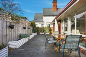 a patio with a wooden table and chairs at Kings Corner in Sandy Bay