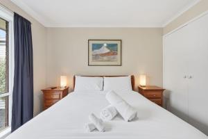 a bedroom with a large white bed with two pillows at Kings Corner in Sandy Bay