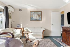 a living room with white furniture and a tv at Kings Corner in Sandy Bay