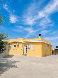 a yellow building with a sky in the background at Casa Vacanza Aria di Mare in Policoro
