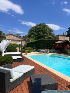 a swimming pool on a wooden deck next to a house at Bastide de montchamp in Malataverne