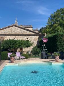 a swimming pool with two chairs and an american flag at Bastide de montchamp in Malataverne