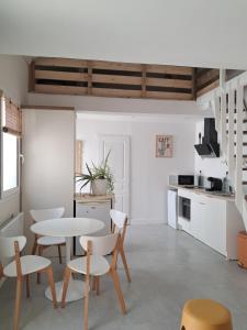 a kitchen and dining room with a table and chairs at Chemin du vieux Puits in Surgères
