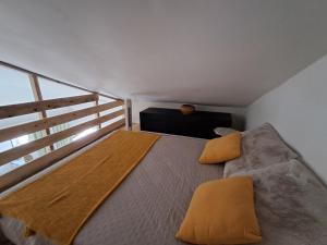 a bedroom with a bed with yellow pillows on it at Chemin du vieux Puits in Surgères