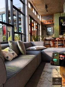 a couch sitting in a room with windows at Lofterra Luxury Apartment in Kozhikode city, calicut in Kozhikode