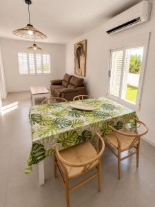 a dining room with a table and chairs and a couch at Los cántaros Apartamento Mojácar in Mojácar