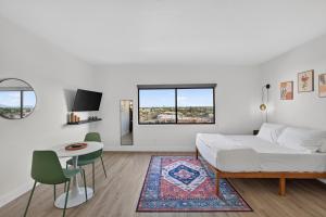 a white bedroom with a bed and a table and chairs at Astral Desert Retreats in Mesa +50 photos