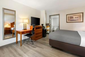 a hotel room with a bed and a desk with a computer at Quality Inn Battleboro - Rocky Mount in Battleboro