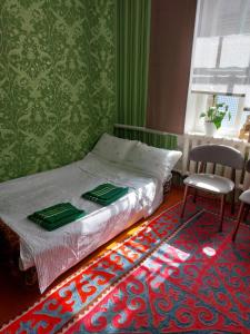 a bedroom with a bed and a chair and a rug at Nomad 114 in Balykchy