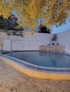 a swimming pool with a fountain in front of a wall at Dar Toubib in Qaşr Chouline