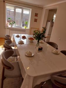 a large white table and chairs in a room at Nomad 114 in Balykchy