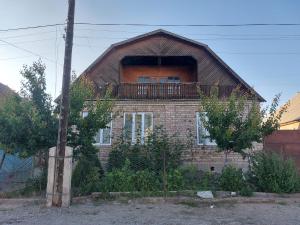 a brick house with a balcony on top of it at Nomad 114 in Balykchy