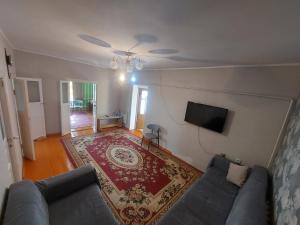 a living room with a couch and a tv at Nomad 114 in Balykchy