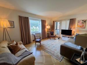 a living room with a couch and a tv at Splendida dimora vista lago in St. Moritz