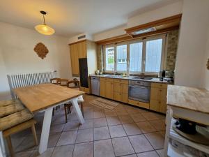 a kitchen with a wooden table and a kitchen with a sink at Splendida dimora vista lago in St. Moritz