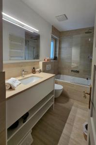a bathroom with a sink and a tub and a toilet at Splendida dimora vista lago in St. Moritz +6 photos