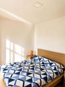 a bedroom with a bed with a blue and white comforter at Lindo Verde T1 in Ventosa