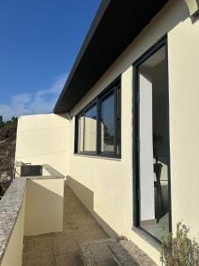 a white house with large sliding glass doors at Lindo Verde T1 in Ventosa