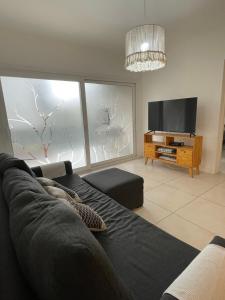 a living room with a couch and a flat screen tv at Vivi Tigre Apart in Tigre