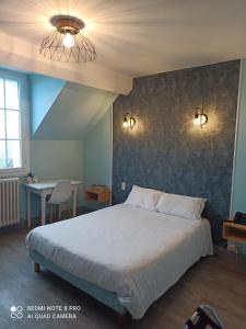 a bedroom with a large bed and a table at Logis Hôtel Auberge de la Gabrière in Lingé