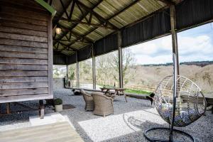 a large screened in porch with a table and chairs at Northcombe Farm Shepherd's Hut in Germansweek