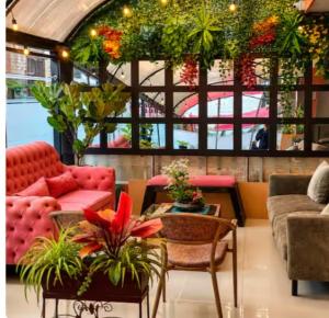 a living room with a red couch and plants at Hotel Casa Lamay in Bogotá