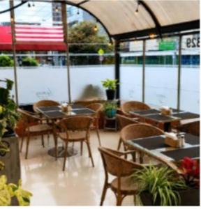 a restaurant with tables and chairs in a room at Hotel Casa Lamay in Bogotá