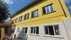 ein gelb-weißes Gebäude mit Fenstern in der Unterkunft Hotel Link Rho in Rho