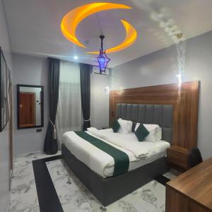 a bedroom with a large bed and a chandelier at Classy Castle Hotel and Suite in Orho Agbarho