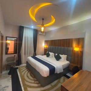 a bedroom with a large bed and a table at Classy Castle Hotel and Suite in Orho Agbarho
