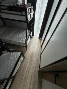 a room with two bunk beds and a wooden floor at Alfa white resort in Koshkolʼ