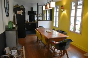 a dining room with a wooden table and yellow walls at La maison de Yan in Cognac