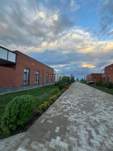 an empty brick road next to a brick building at Alfa white resort in Koshkolʼ