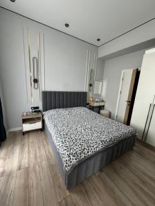 a bedroom with a large bed and a wooden floor at Alfa white resort in Koshkolʼ