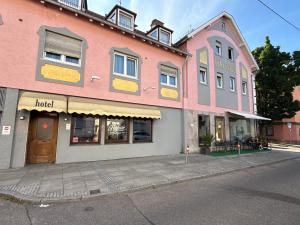 a pink building on the side of a street at Hafner Hotel Apartment Stuttgart in Stuttgart