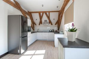 a kitchen with white walls and wooden beams at B&B Wieniawa in Leszno
